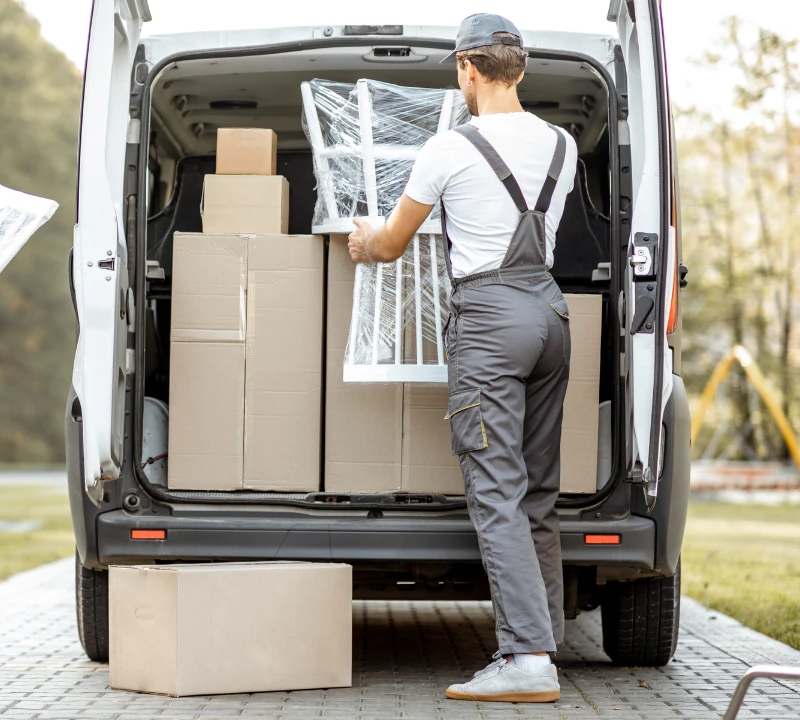 Umzugshelfer lädt Kartons und Möbel in Transporter – Tresortransport Bielefeld